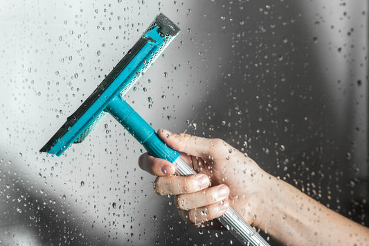 a hand holding a window squeegee