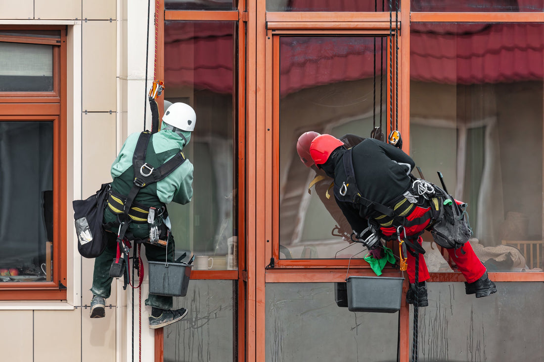 Workers washing windows at exterior building 