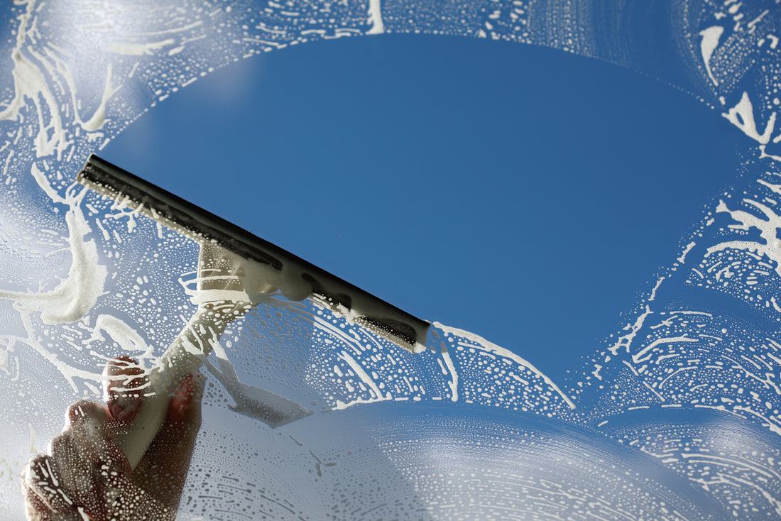 window squeegee clearing a soapy window