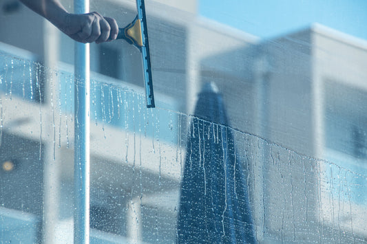 Close-up view of a hand using a squeegee to clean a